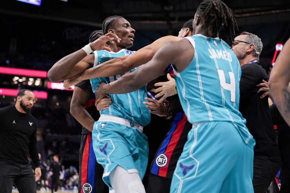 Charlotte Hornets forward Moussa Diabaté is held back by guard Sion James while engaging with Detroit Pistons forward Tobias Harris during the second half at Spectrum Center.