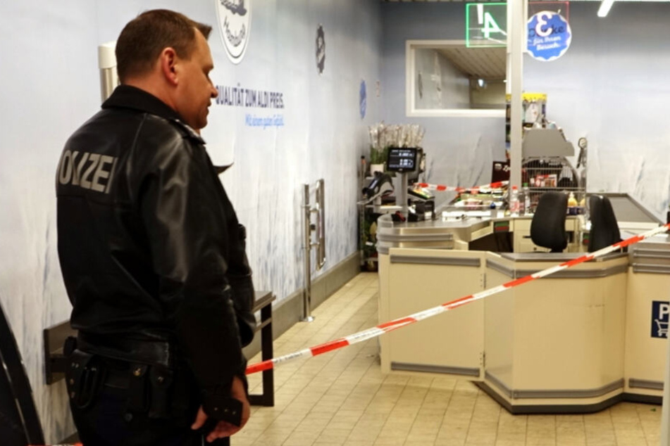 Ein Polizist steht vor einem Absperrband am Tatort.