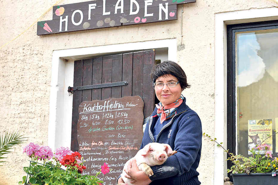 Bäuerin Friede (40) aus Gröbern hält ein Meissner Landschwein im Arm.