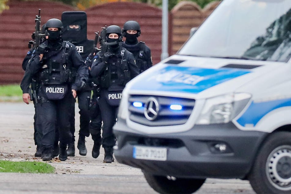Polizisten gehen bewaffnet durch den Ort Wiedersdorf/Landsberg. Neben den Schüssen in Halle hat es auch Schüsse im rund 15 Kilometer entfernten Landsberg (Saalekreis) gegeben.