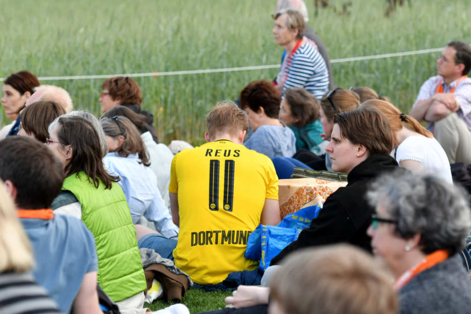 Manche verbinden gleich beides bei ihrem Berlin-Ausflug: Ein BVB-Fan beim Feierabendmahl an der Bernauer Straße.