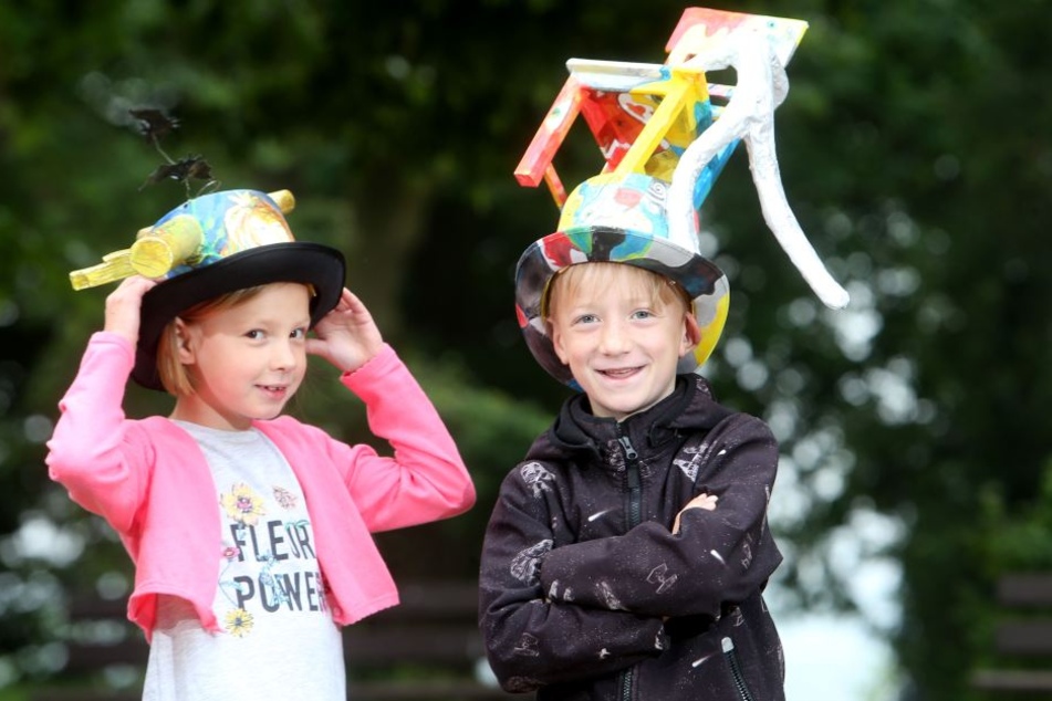 Laura (7, l.) und Oskar (7) haben sich kreative Hüte gebaut.