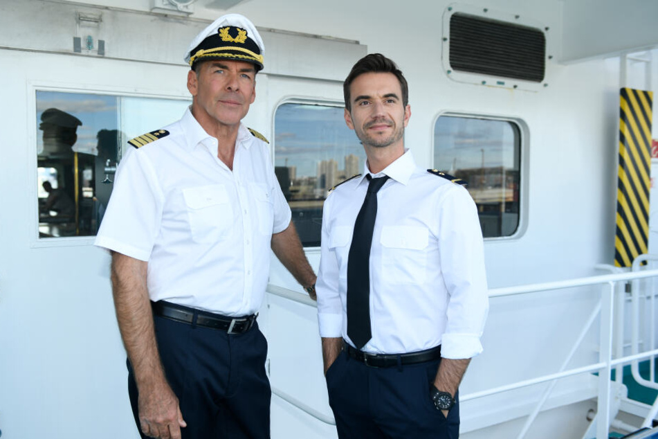 Alt und neu: Kapitän Burger (Sascha Hehn, l) und der junge Offizier Florian (Florian Silbereisen) stehen in der Folge "Das Traumschiff: Tansania" auf der Brücke des Schiffs.