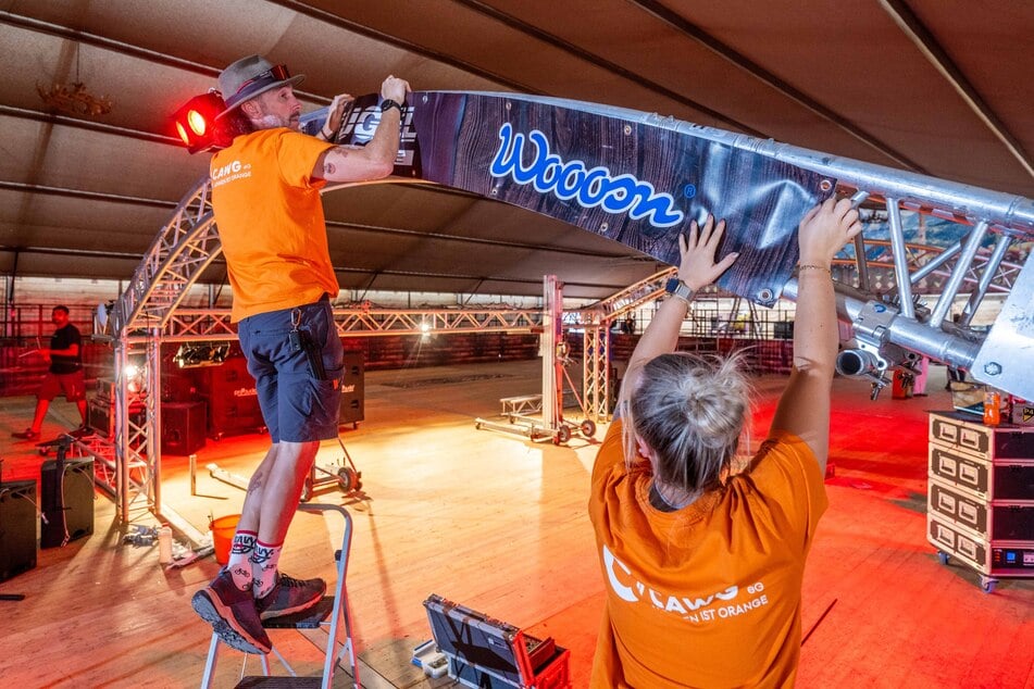 Alexander Liebers (47) und Celine Schellenberger (24) bringen Banner an.