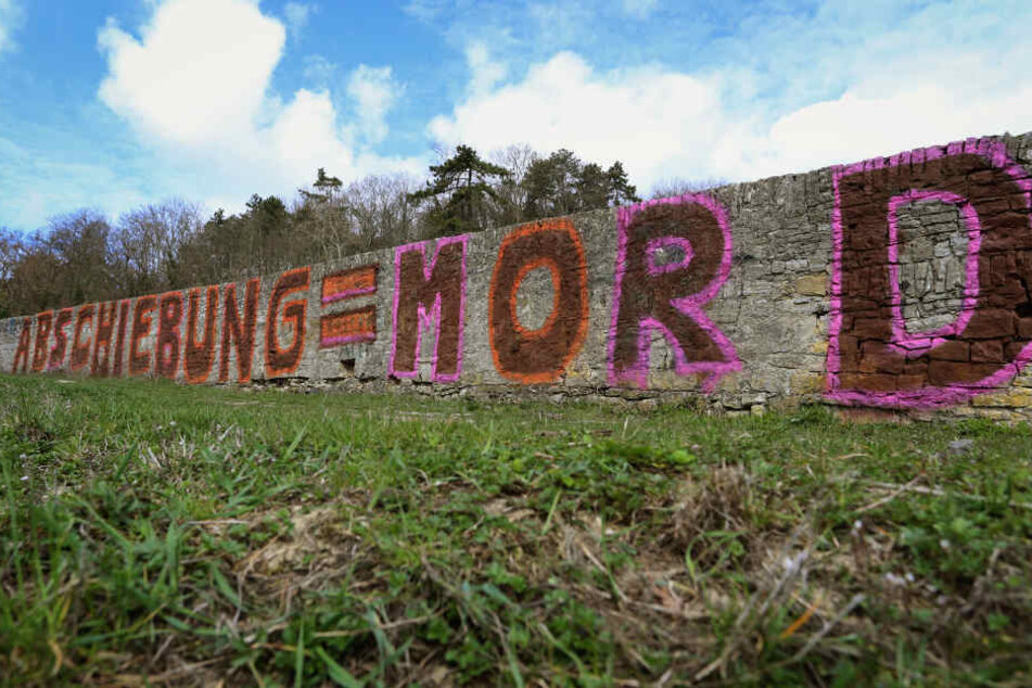 In riesigen Buchstaben wurde die Parole "Abschiebung = Mord" auf der Steinwand angebracht.