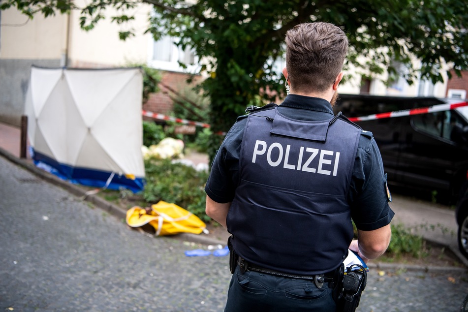 Ein Polizist steht am Ort eines Polizeieinsatzes.