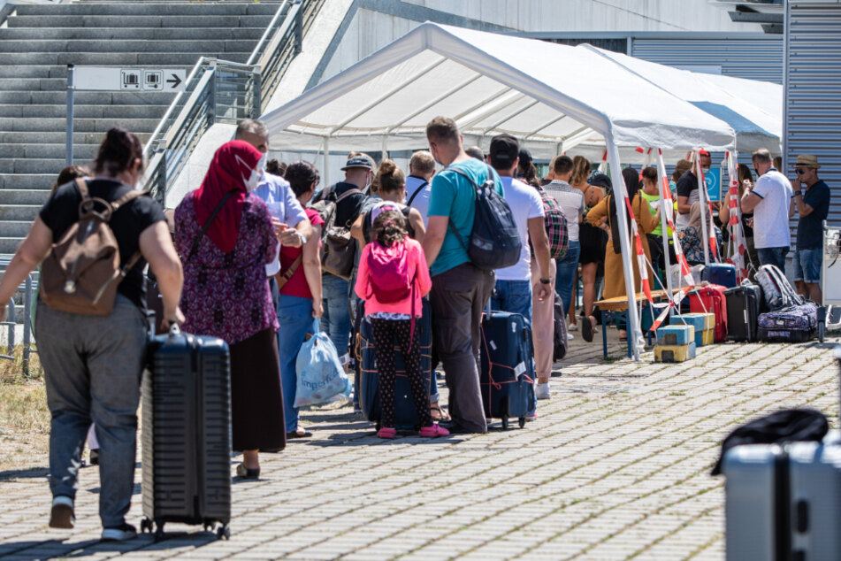 Reiserückkehrer stehen vor dem Corona-Testzentrum am Flughafen.
