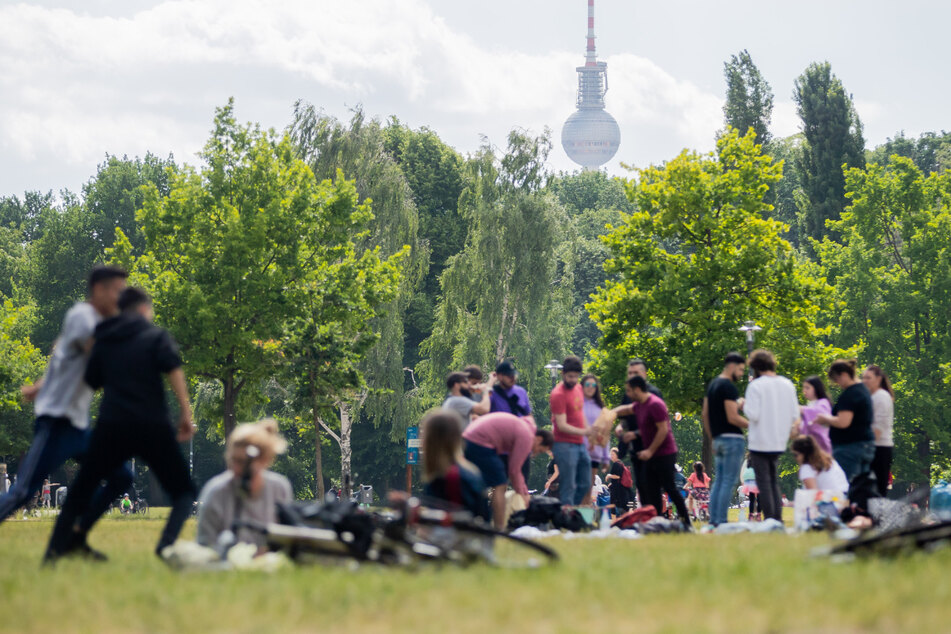 Menschen grillen und genießen das warme Wetter im Volkspark Friedrichshain. Künftig können sich bis zu 100 Personen im Freien treffen.