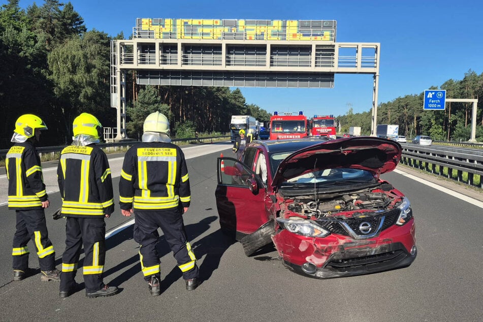 Feuerwehrleute begutachten den zerstörten Nissan.