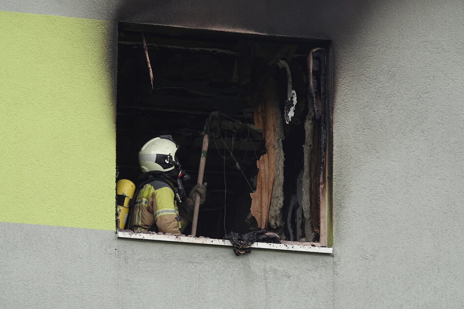 Ein Feuerwehrmann mit Atemschutz inspiziert die Brandwohnung.