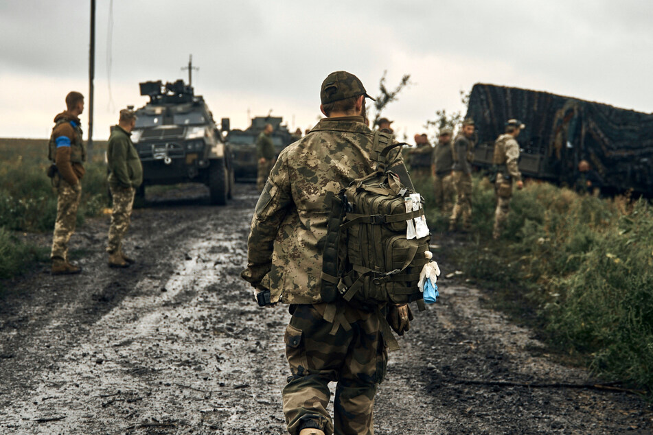 Ukrainische Soldaten stehen auf einer Landstraße.