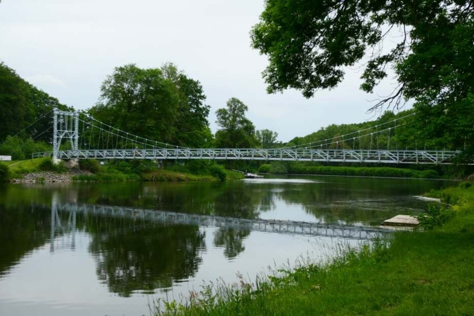 Auf dieser Hängebrücke über die Mulde in Grimma hat sich eine Gruppe mit Traktor und Anhänger mit Entgegenkommenden angelegt.