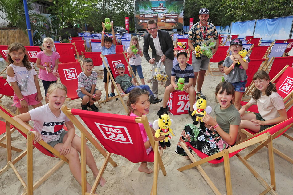 Mario Menzel (54, Sparkasse, l.) und René Ulbrich (43, TAG24) übergaben den "Pusteblume"-Hortkindern vor dem Filmstart kleine Geschenke.