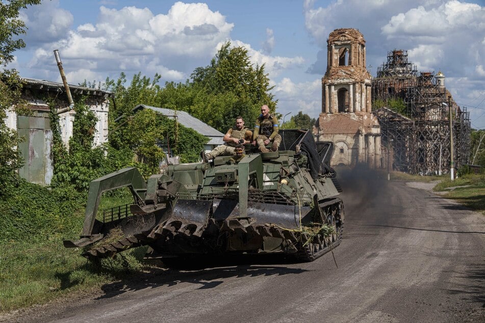 Ukrainische Soldaten fahren auf einem gepanzerten Fahrzeug an der russisch-ukrainischen Grenze in der Stadt Sumy. (Archivbild)