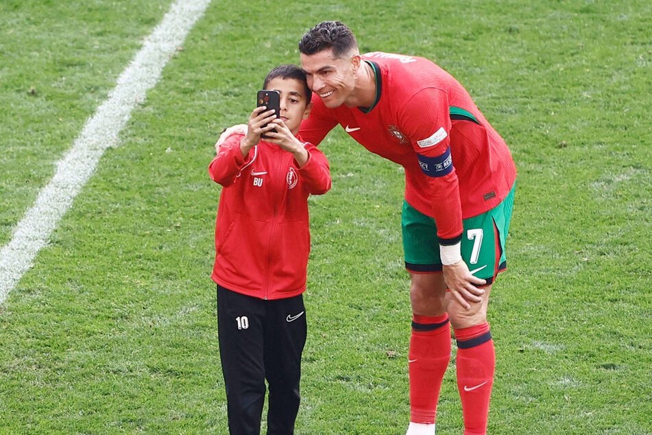 Berat (10) rannte während des 3:0-Sieges von Portugal gegen die Türkei auf den Dortmunder Rasen und ergatterte ein Selfie mit Cristiano Ronaldo (39).