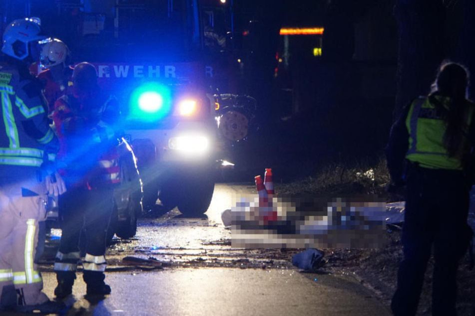 Die beiden Leichen liegen abgedeckt am Straßenrand.