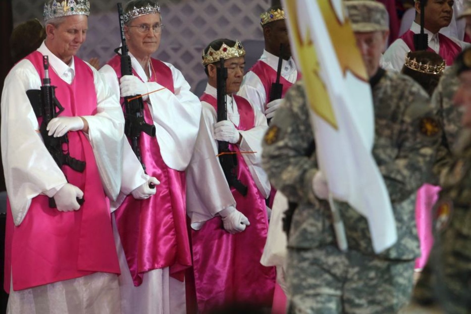 Die Priester tragen während des Gottesdienstes Waffen.