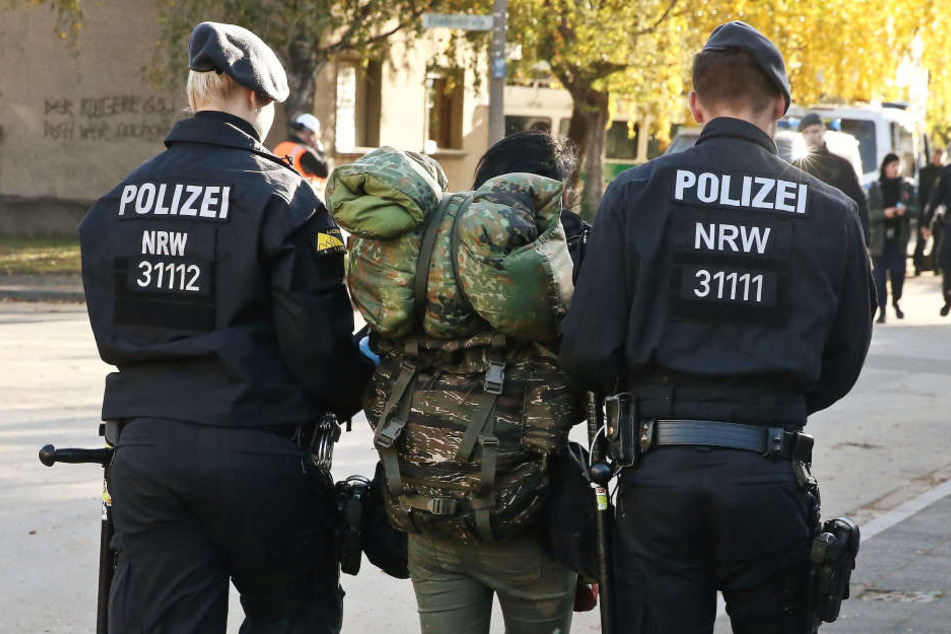 Polizisten führen im Stadtteil Manheim einen Aktivisten ab.