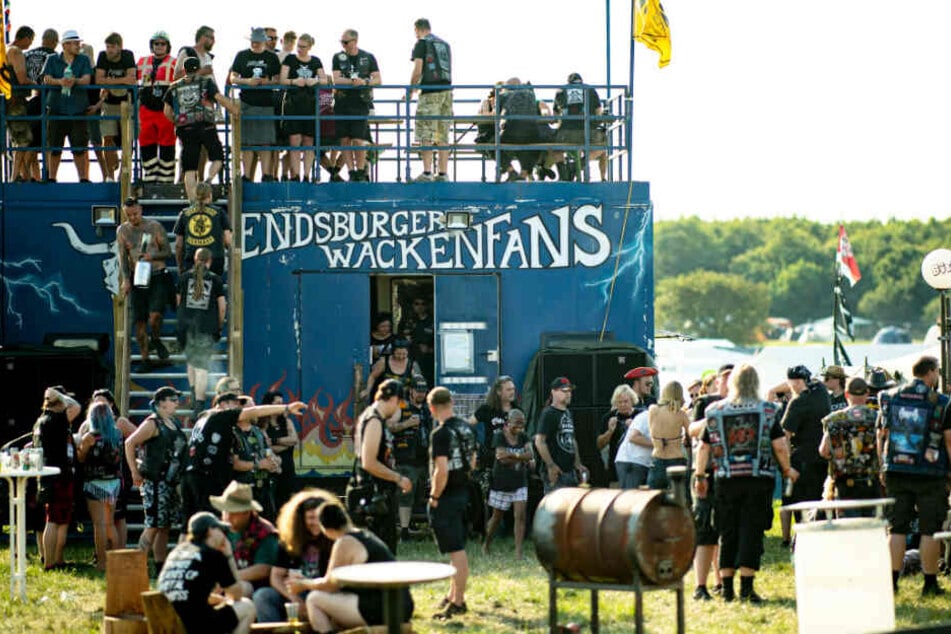 Auf einer selbstgebauten Aussichtsplattform feiern Wacken-Besucher bereits vor Festivalbeginn.
