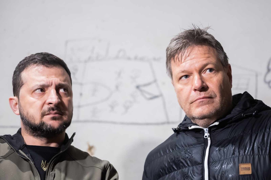 Robert Habeck (53, Grüne, r) und Wolodymyr Selenskyj stehen nordöstlich von Kiew in einem Schulkeller, in dem Geiseln gehalten wurden, vor einer Wand mit Bildern der Gefangenen.