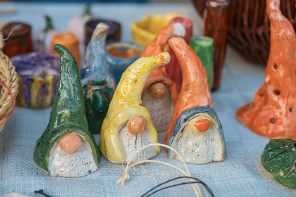Die Kinder zeigen ihre selbstgefertigten Töpfereien, die gegen eine Spende zu haben sind.