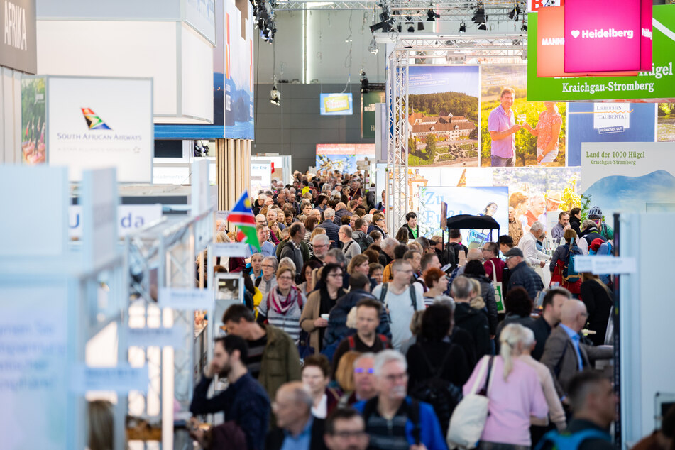 Besucher gehen bei der Reisemesse CMT durch eine Halle der Messe Stuttgart.