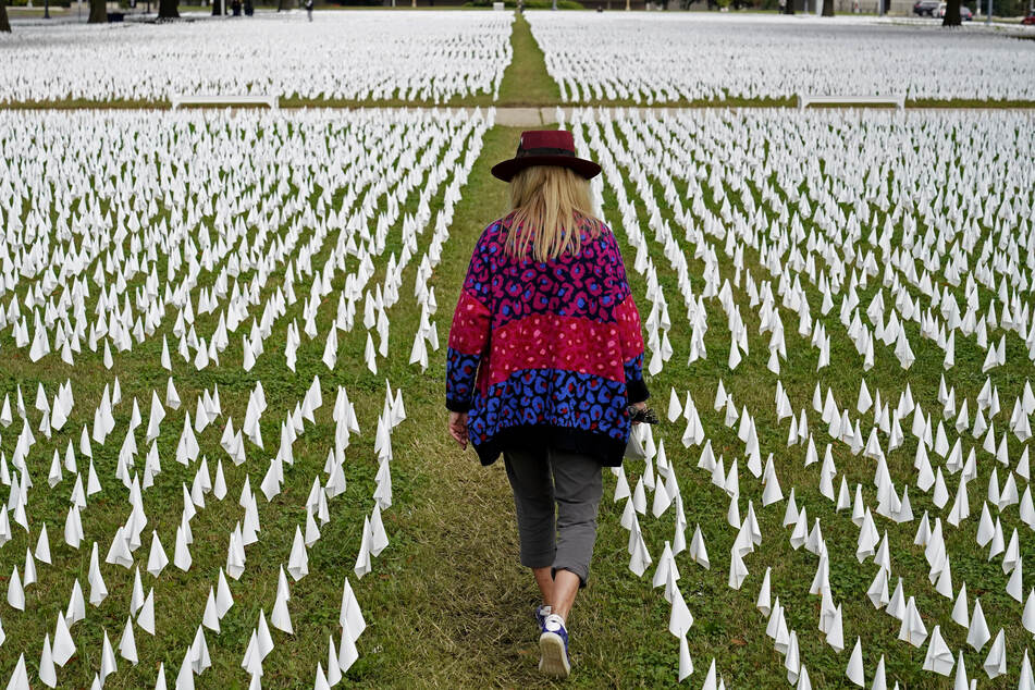 Die Künstlerin Suzanne Brennan Firstenberg geht durch ihre Kunstinstallation aus weißen Fänchen, die im Gedenken an die an COVID-19 verstorbenen US-Amerikaner in der Nähe des Robert F. Kennedy Memorial Stadiums in den Boden gesteckt wurden.