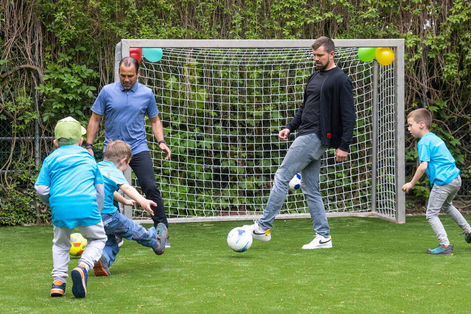 Ulf Kirsten (57, l.) und Sohnemann Benny (35) kicken auf dem neuen Bolzplatz mit dem Nachwuchs.