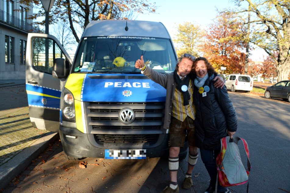 Vor dem Kühler mit der Aufschrift "Peace"warten Florian (59) und Snezana (54) aus München auf ihre Abfahrt im Autokorso zum Augustusplatz.