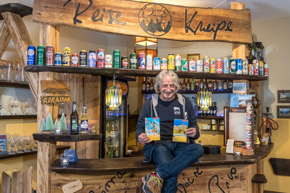 Stolz zeigt Ray Hartung (63) in der Reisekneipe seine beiden Reiseführer.