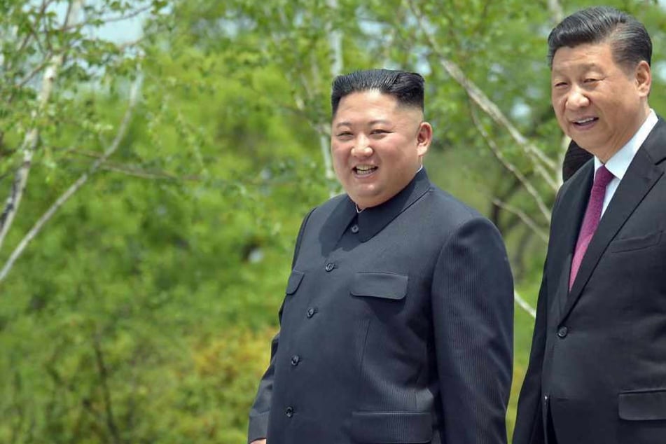 This June 21, 2019 picture released from North Korea's official Korean Central News Agency (KCNA) on June 22, 2019 shows China's President Xi Jinping (R) and North Korean leader Kim Jong Un (L) walking at the Kumsusan State Guest House in Pyongyang.