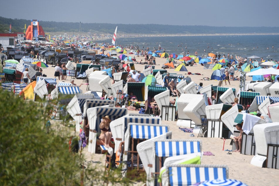 Touristen nutzen am Samstag das hochsommerliche Wetter am Strand von Zinnowitz auf der Insel Usedom zum Sonnen und Baden.