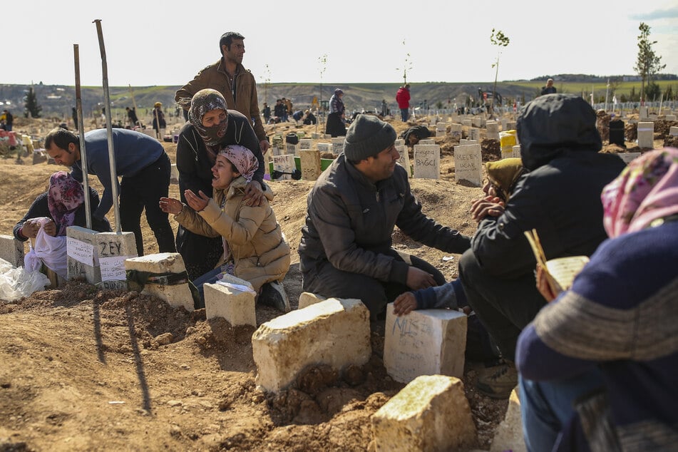 Menschen trauern auf einem Friedhof in Adiyaman, wo sie ihre Angehörigen begraben. Auch aus Deutschland wollen Angehörige anreisen, um sich von ihren Angehörigen zu verabschieden.