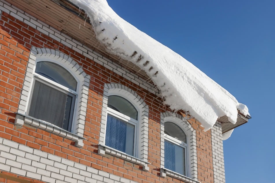 Um Unfälle und Schäden durch herabfallenden Schnee zu verhindern, sollte man Schnee vom Dach entfernen.
