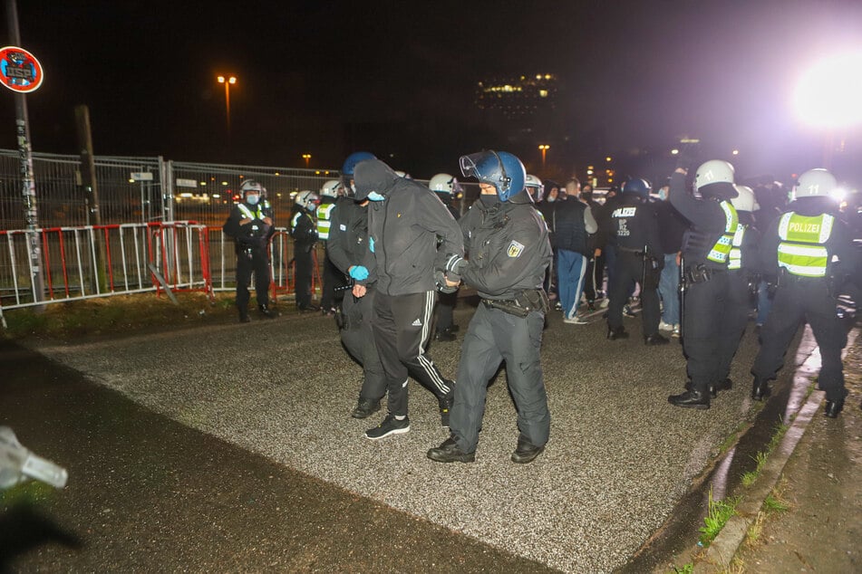Die Polizei führt beim Millerntor-Stadion einen Mann ab. Am Freitagabend gab es eine Auseinandersetzung zwischen HSV- und St.-Pauli-Fans.