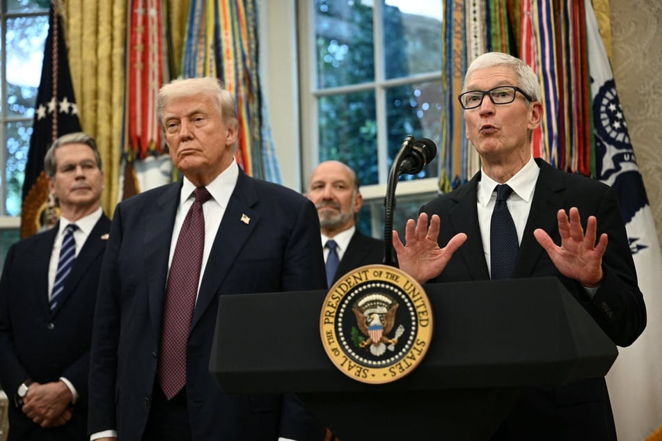 Apple CEO Tim Cook (r.) speaks as US President Donald Trump, (second from l.), Commerce Secretary Howard Lutnick (second from r.), and Treasury Secretary Scott Bessent (l.) look on in the Oval Office of the White House on August 6, 2025.
