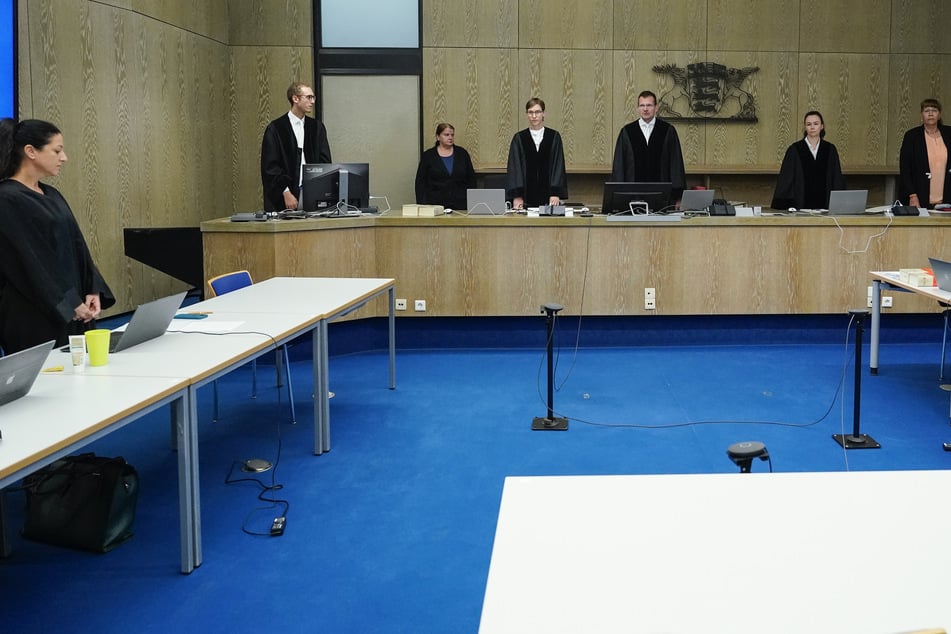 Inga Berg (l.), Verteidigerin des Angeklagten, stand im Verhandlungssaal des Landgerichts Mannheim bei Einzug des Richters Gerd Rackwitz (5.v.l.) neben einem leeren Stuhl. Der Beschuldigte erschien erst, nachdem Fotografen und Videografen den Saal verlassen hatten.