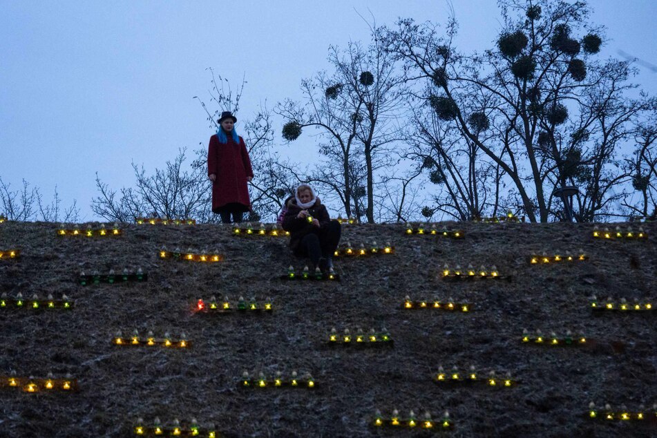 Menschen in Kiew zünden Kerzen auf einem Hügel an einem Denkmal für die Opfer der Großen Hungersnot von 1932/33 an.