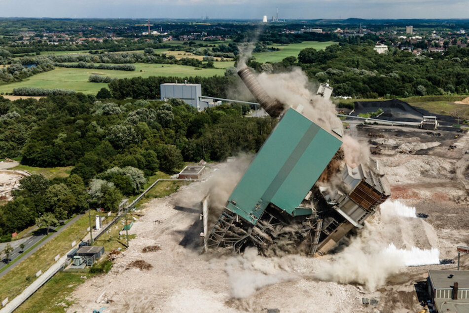 Auf dem Gelände des ehemaligen Steag-Kraftwerks fallen ein Schornstein, ein Bunkerschwerbau und ein Kessel bei der Sprengung am Samstag in sich zusammen.