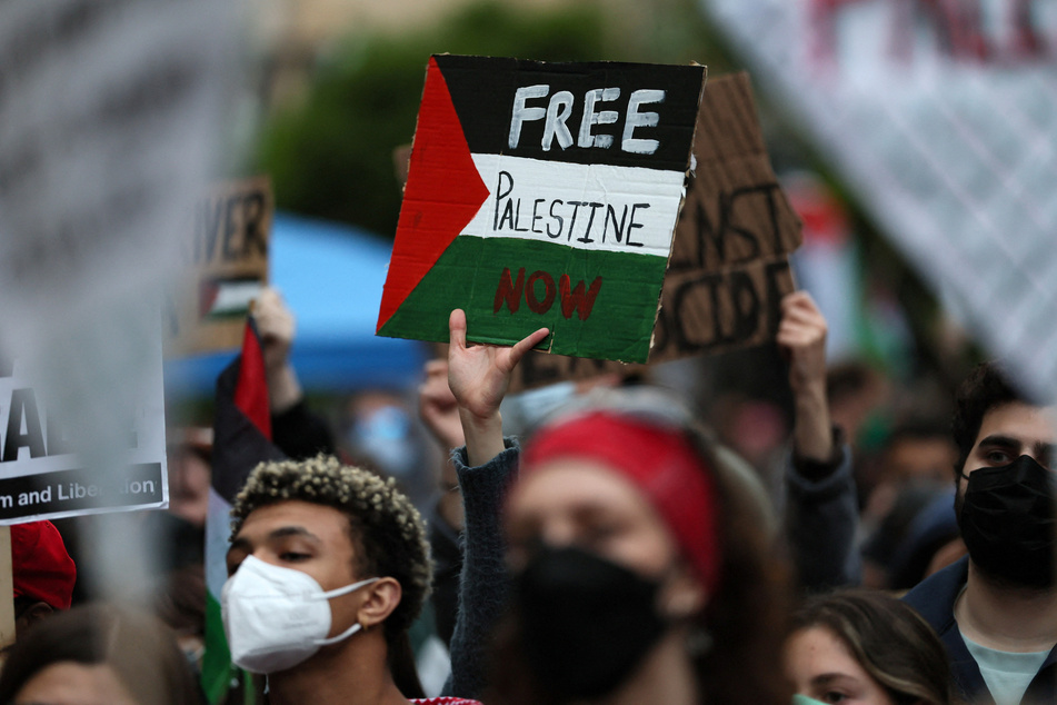 A George Washington University student holds a sign reading "Free Palestine Now" amid a growing protest movement in solidarity with Gazans under siege.