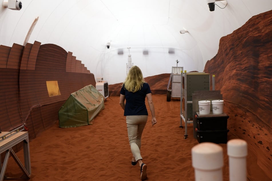 Dr. Suzanne Bell, Lead for NASA’s Behavioral Health and Performance Laboratory, walks through a simulated Mars exterior portion of the CHAPEA’s Mars Dune Alpha at the Johnson Space center in Houston, Texas on April 11, 2023.