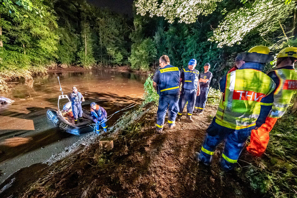 Rettungskräfte sichern einen Teich bei Fröndenberg dessen Deich durch sintflutartige Regenfällen aufgeweicht wurde und zu brechen droht.