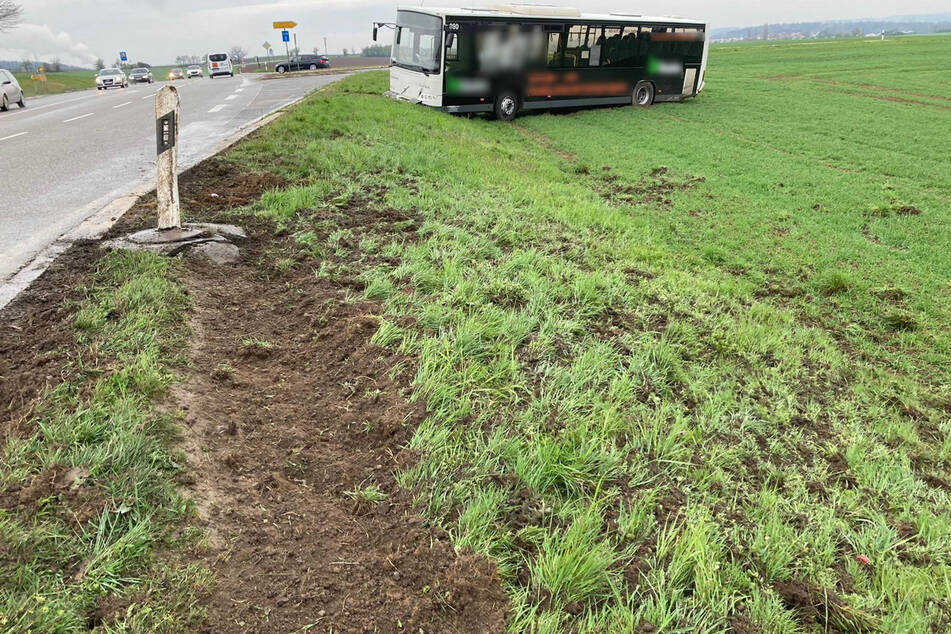 Der Bus steht auf einem Feld neben der Fahrbahn.