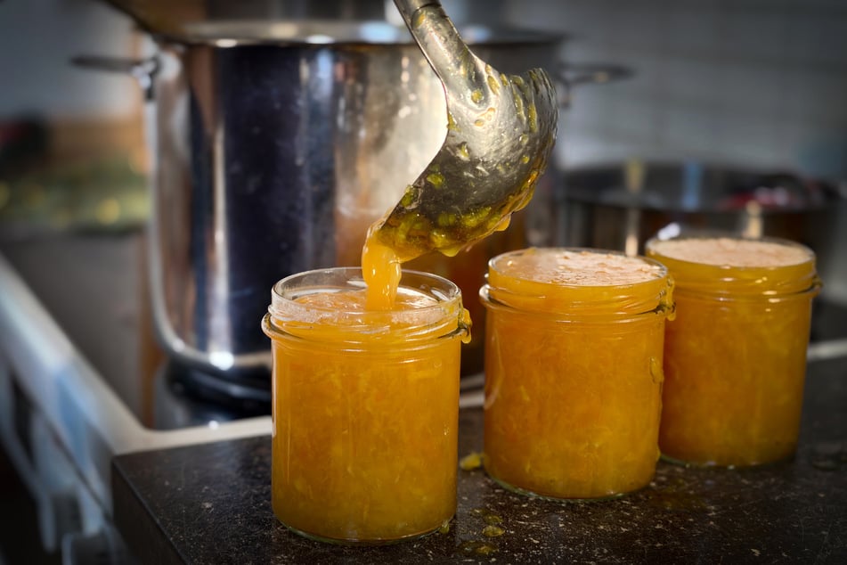 Kochend heiß wird die fertige Orangenmarmelade in Gläser gefüllt.