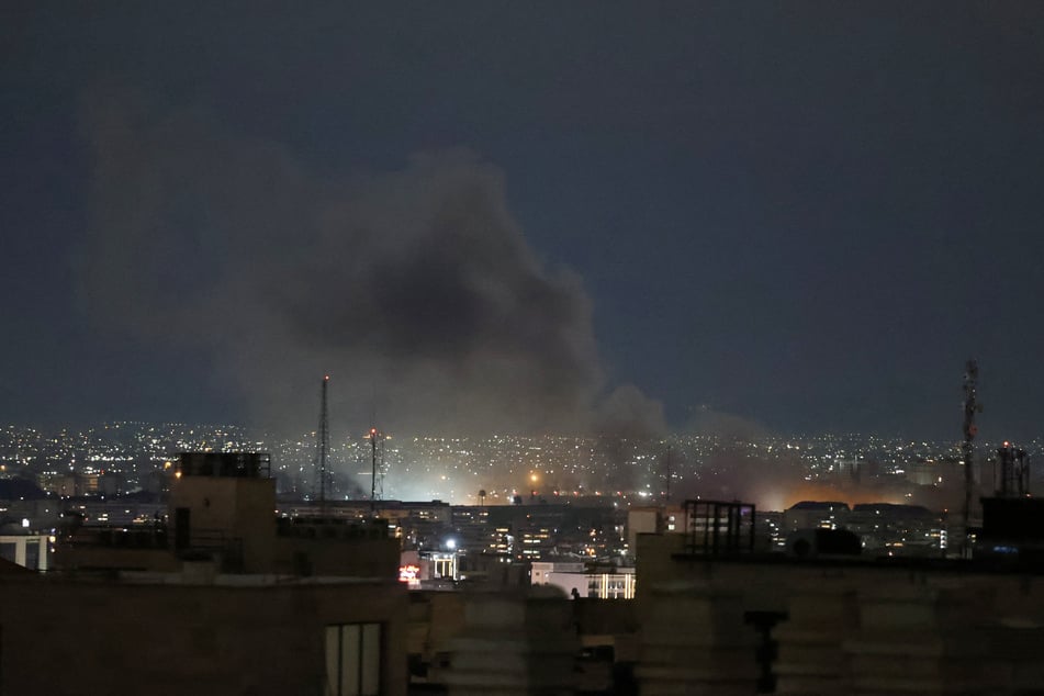 A plume of smoke rises from the site of a strike in Tehran, Iran, late on March 28, 2026.