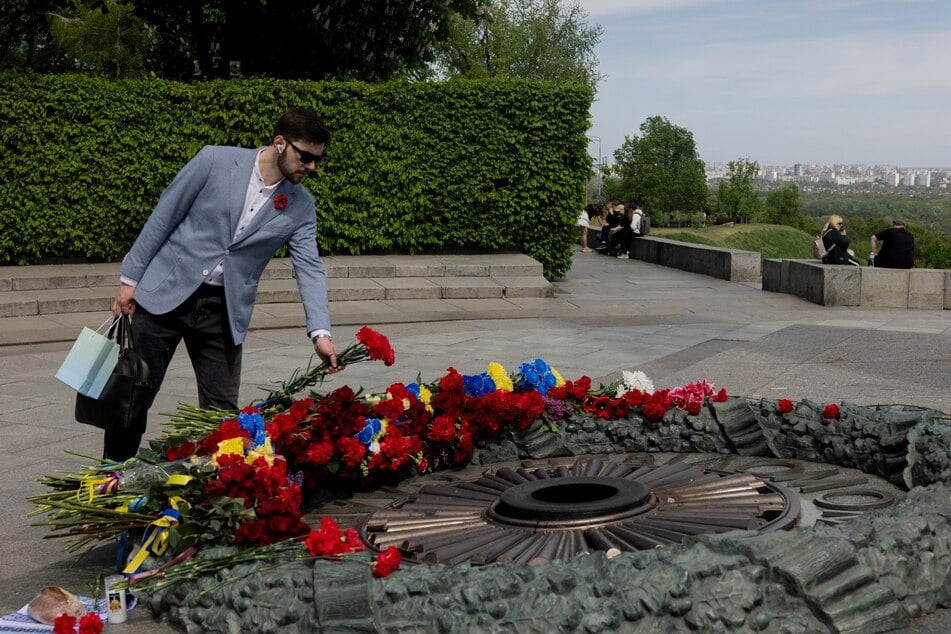 A man lays a flower bouquet on the Tomb of the Unknown Soldier at the WWII memorial on the 81st anniversary of Victory in Europe Day in Kyiv, Ukraine, on May 8, 2026.