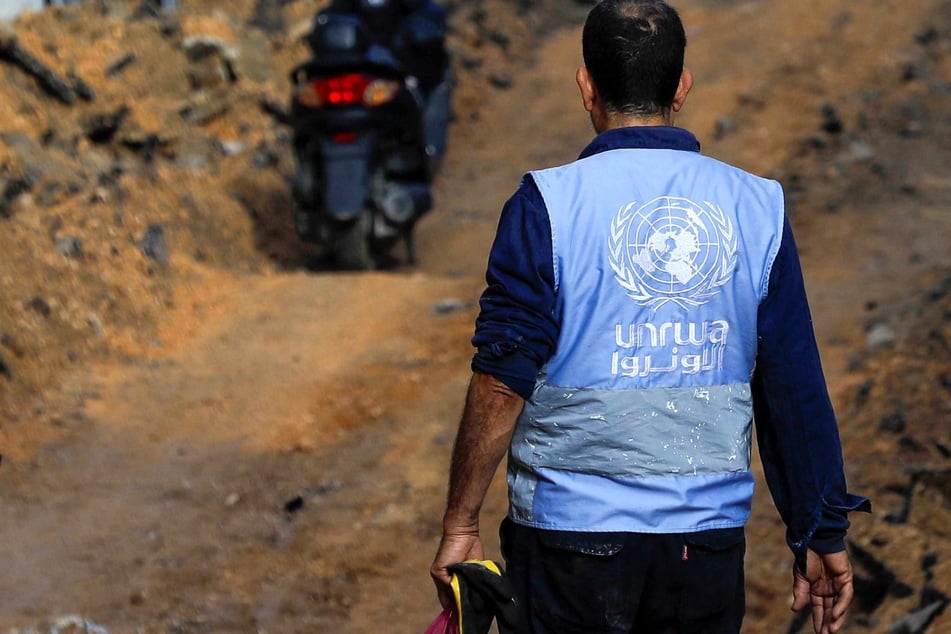 A man wearing a jacket of the UN Agency for Palestinian Refugees (UNWRA) walks on a street that has been bulldozed by the Israeli forces during a raid in Jenin in the occupied West Bank on January 29, 2024.