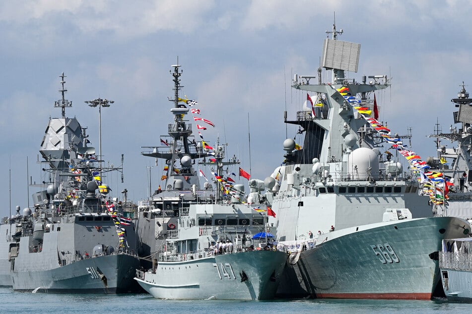 Chinese Navy missile frigate Yulin (R) and the minesweeper hunter Chibi (C) are seen docked at Changi Naval Base during the IMDEX Asia warships display in Singapore on May 4, 2023.