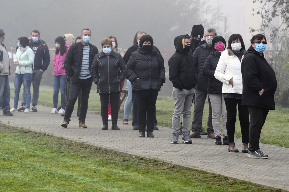 Menschen warten darauf im Dorf Raslavice im Bezirk Bardejov auf den Coronavirus getestet zu werden.