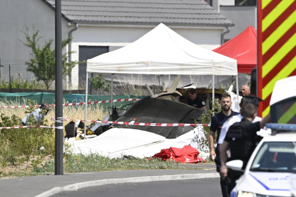 Experten untersuchen den Flieger an der Unfallstelle.